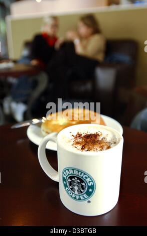 (Dpa) - eine Tasse Starbucks Cappuccino ist vor einem Teller mit einem Kuchen in einem Café der Starbucks-Kaffee-Kette in Köln, 14. Juni 2003 gesehen. Im Vergleich zu anderen Cafés Starbucks bietet eine größere Auswahl an Kaffees, aber die Preise sind höher als die durchschnittliche Cafés: ein Café au Lait kostet Stockfoto