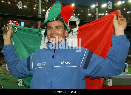 (Dpa) - italienische Stabhochspringer Giuseppe Gibilisco trägt ein Hofnarr Hut in italienischen Farben und Flagge seines Landes um seinen Sieg im Stabhochsprung-Wettbewerb bei der 9. athletische Weltmeisterschaften im Stade de France in Paris, 28. August 2003 zu feiern. Er war der einzige Athlet Stockfoto