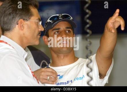 (Dpa) - kolumbianische Formel 1 pilot Montoya (BMW-Williams) verweist auf eine elektronische Datenbildschirm während des Sprechens in BMW Sportdirektor Mario Theissen (L) auf der Rennstrecke Hungaroring in der Nähe von Budapest, Ungarn, 22. August 2003. Montoya ranking ist derzeit zweiter in der Gesamtwertung. Die 13. Stockfoto