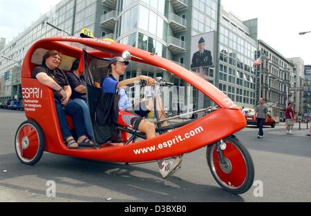 (Dpa) - sitzen Touristen auf der Rückseite ein Velo-Taxi während der Fahrer Pedale in einer Straße in der Nähe der berühmten ehemaligen Grenze Corssing "Checkpoint Charly" in Berlin, 1. Juli 2003. Die Stadt hat eine Werbung Zweitausendeins um mehr Touristen zu th Kapital anzuziehen. A ' herzlich willkommen ' Sonderangebote Touristen Ove Stockfoto