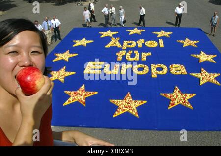 (Dpa) - Mira nimmt einen Bissen des Apfels vor einer europäischen Flagge steht mit seinen gelben Sternen aus Äpfeln und das Schreiben "Äpfel für Europa" auf einem Platz in Köln, 8. August 2003. Der Europäischen Apple Kongreß Prognosfruit hatte die Fahne mit etwa 2.000 Äpfel gebildet. Äpfel gehören zu den Stockfoto