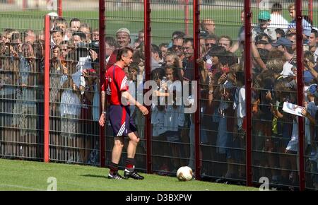 (Dpa) - zahlreiche Bayern-Fans nach vorne schieben, um einen Blick auf Ottmar Hitzfeld (vorne), die Trainer der deutschen Fußball-club FC Bayern München, bekommen einen Ball in der Nähe der Barriere, in München, 7. August 2003. Stockfoto