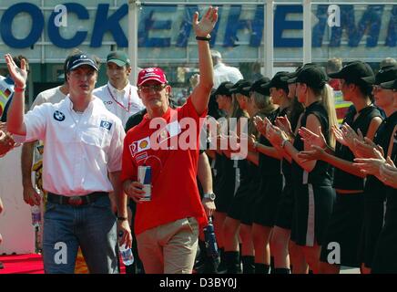 (Dpa) - der deutsche Formel 1-Piloten Ralf (L, BMW-Williams) und seinem Bruder Michael Schumacher (Ferrari) Welle Eintreffen an der Rennstrecke von Hockenheim in Hockenheim, Deutschland, 3. August 2003. Stockfoto