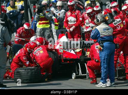 (Dpa) - Ferrari-Mechaniker hektisch ändern die Reifenpanne Schumachers Rennwagen während der Formel 1 Grand Prix von Deutschland auf der Rennstrecke von Hockenheim in Hockenheim, Deutschland, 3. August 2003. Deutschlands Michael Schumacher war an zweiter Stelle, als seine Reifen während des Rennens mit vier l platzen Stockfoto