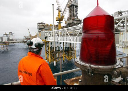 (Dpa) - ein Arbeiter steht auf dem Prüfstand Gas- und Ölvorkommen in der Nordsee, etwa 250 km vor der Küste von Stavanger, Norwegen, 5. Juli 2003. Auf der rechten Seite Schiffe eine riesige Positionslicht für. Die Plattform gehört das Ekofisk-Feld Komplex, umfasst der Öl- und Gasindustrie Rigs Ekofisk, Eldfisk, Embla und Tor. Die Arbeiter Stockfoto