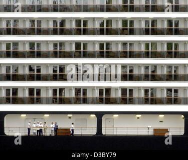 (Dpa) - stehen Crew-Mitglieder des Kreuzfahrtschiffes Oosterdam auf Deck als das Schiff Docks in Hamburg, 31. Juli 2003. Die Oosterdam ist das zweitgrößte Schiff überhaupt, am deutschen Hafen ankommen. Das Schiff von Holland America Line wird auf seiner Jungfernfahrt durch die Nordsee für eine Kreuzfahrt zu Ro verlassen Stockfoto