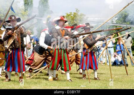 (Dpa) - Musketiere feuern ihre Musketen, wie sie den Dreißigjährigen Krieg (1618-1648) während einer Geschichte-Festival in den Elbauen-Park in Magdeburg, Deutschland, 12. Juli 2003 nachspielen. Während des Dreißigjährigen Krieges, in ganz Mitteleuropa wütete, wurden die Gegner auf der einen Seite das Haus Österreich: Stockfoto