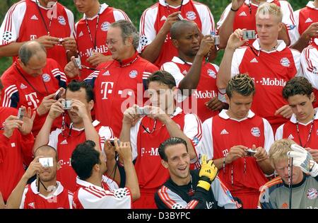 (Dpa) - posieren die Spieler der deutschen Fußball-Meister FC Bayern München mit Kameras von einem Sponsor während ein Fotoshooting in ihr Heimstadion in München, 24. Juli 2003. Stockfoto