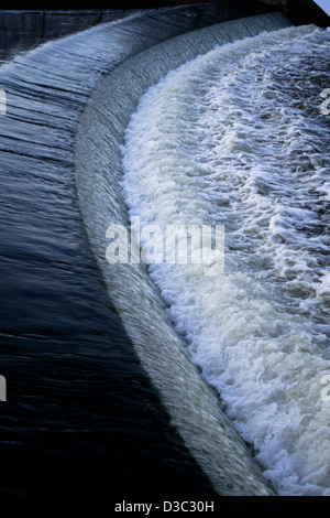 Wasser fließt über ein Wehr in Costessey Mill auf den Fluss Wensum in Norfolk Stockfoto