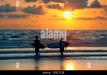 Silhouetten von drei Surfer im Abendrot. Kuta Beach. Bali Stockfoto