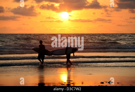 Silhouetten von drei Surfer im Abendrot. Kuta beach Stockfoto