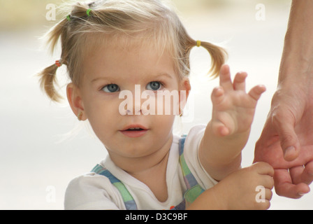 Babymädchen amüsiert über die Kamera während des Spielens Stockfoto