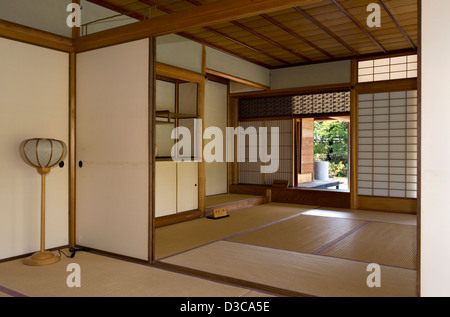 Natürliche warme Holztöne, Tatami-Matten-Boden und schiebbare Shoji-Bildschirme in traditioneller japanischer Architektur in einem Wohnhaus in Japan. Stockfoto