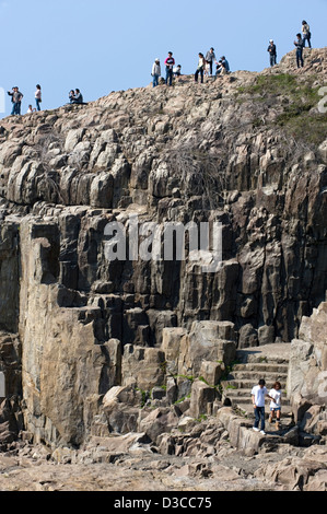 Sonnigen Tagestouristen genießen die Aussicht von oben auf die schroffen, felsigen Küste auf dem Meer von Japan in der Nähe von Tojimbo, Fukui, Japan. Stockfoto