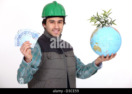 Kaufmann hält einen Globus und einen Batzen Geld Stockfoto