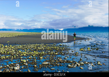 Mann läuft hart an Bischof Strand, Homer, Alaska, USA Stockfoto