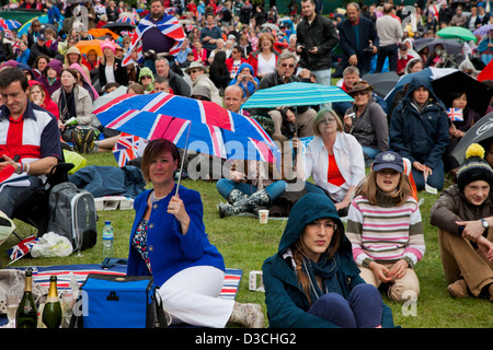 Menschen die Teilnahme an Diamanten Jubiläumsfeier in St James' Park beobachten der Königin Prozession auf outdoor Bildschirmen. Stockfoto