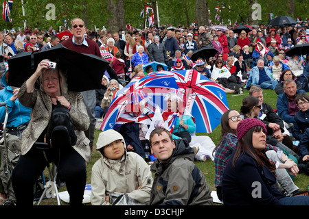 Menschen die Teilnahme an Diamanten Jubiläumsfeier in St James' Park beobachten der Königin Prozession auf outdoor Bildschirmen. Stockfoto