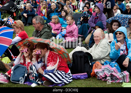 Menschen die Teilnahme an Diamanten Jubiläumsfeier in St James' Park beobachten der Königin Prozession auf outdoor Bildschirmen. Stockfoto