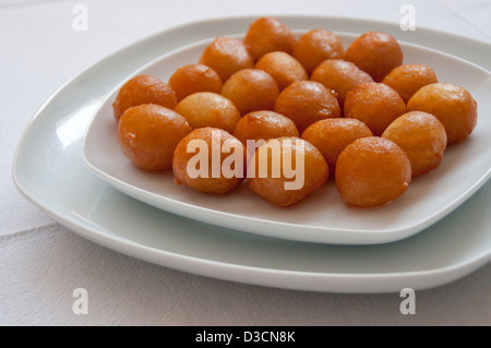 Gebratenes Teiggebäck aus frittiertem Teig, getränkt in Zuckersirup oder Honig und Zimt und manchmal mit Sesam bestreut Stockfoto