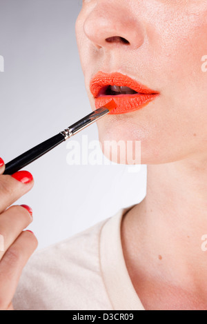 Frau Lippenstift mit Pinsel auftragen Stockfoto