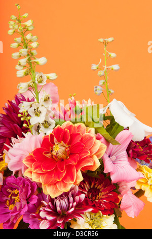 Bunter Strauß Blumen auf orangem Hintergrund Stockfoto
