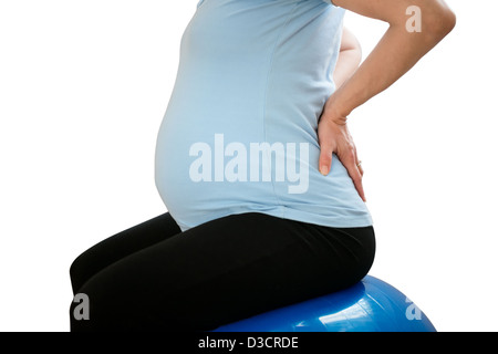 Schwangere Frau sitzen auf Fit Ball mit Rückenschmerzen - isoliert auf weiss Stockfoto