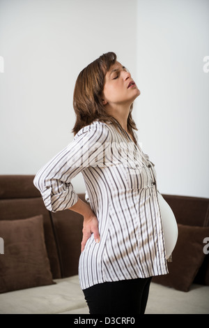 Schwangere Frau sitzen auf Fit Ball mit Rückenschmerzen Stockfoto