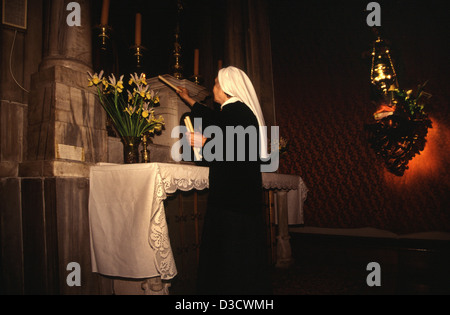 Eine katholische Nonne zündet Kerzen an, während sie in der St. Blaise-Kirche in der Altstadt von Dubrovnik Kroatien betet Stockfoto