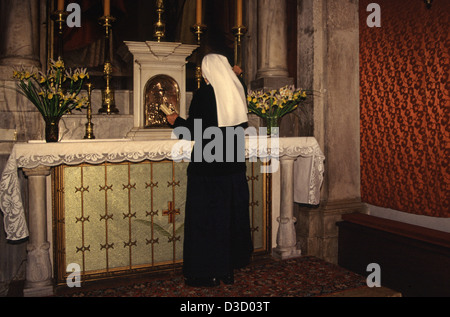 Eine katholische Nonne zündet Kerzen an, während sie in der St. Blaise-Kirche in der Altstadt von Dubrovnik Kroatien betet Stockfoto