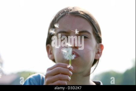 Leipzig, Deutschland, bläst Mädchen um ein Löwenzahn Stockfoto