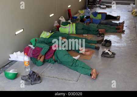 Dubai, Vereinigte Arabische Emirate, Bauarbeiter in ihrer Pause auf dem Boden schlafen Stockfoto