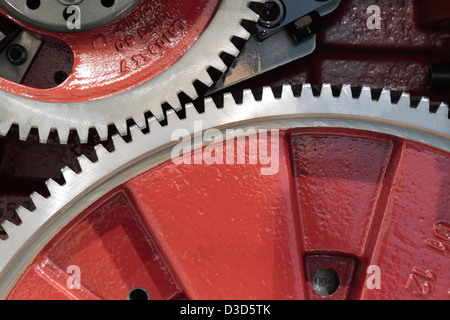 Ölige rote Zahnräder ineinandergreifen zusammen in ein Räderwerk Stockfoto