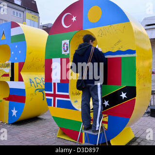 Junge kosovarische Menschen malen, die 3 Meter hohe Metall-Lettern lesen "New Born" in Vorbereitung für den Unabhängigkeitstag feiern, Pristina, Kosovo, Samstag, 16. Februar 2013 internationale Flaggen auf die Outdoor-Skulptur von Fisnik Ismajli aus. Kosovo erklärte Unabhängigkeit 2008 und feierte seinen fünften Geburtstag am Sonntag, 17. Februar 2013. Stockfoto