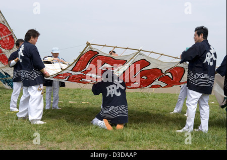 Team der Männer in Happi Mäntel bekommen einen großen Papier und Bambus Drachen an der Sagami-Drachenfest in Kanagawa startbereit. Stockfoto