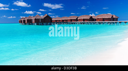 Overwater-Villen in der tropischen Lagune mit weißem Sandstrand Stockfoto