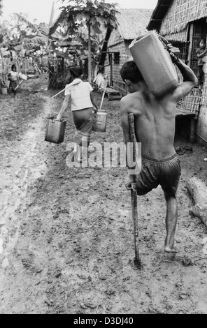 Der thailändisch - kambodschanischen Grenze, Thailand: Seite 8, das Khmer Rouge "Schaufenster" Lager 2 km von der Grenze entfernt, beherbergt 33.000 Menschen. . Hier trägt ein KR-Soldat, der verloren hat, ein Bein auf eine Mine treten Wasser zurück zu seinem Haus. Stockfoto