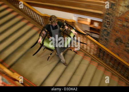 LONDON, ENGLAND - März 2004: Christies Auktion Haus Mitarbeiter tragen Stühle aus einem Satz von vierzehn caned offenen Sessel von William Thoms bei King Street nach Möbel Verkauf. Stockfoto