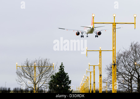 EasyJet Flugzeug fliegen über Landebahn Landescheinwerfer an einem Flughafen Stockfoto