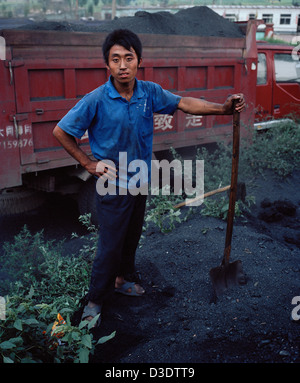 DATONG, Provinz SHANXI, CHINA - AUGUST 2007: 15 Jahre alter Junge Schaufeln Kohle Staub auf einen LKW mit zwei anderen Jugendlichen. Stockfoto