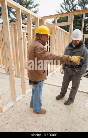 Bauleiter diskutieren Hausbau mit Zimmermann Stockfoto