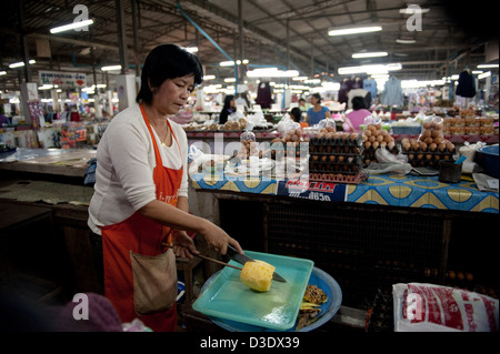 Fang, Thailand, eine Verkäuferin eine Ananas schneiden Stockfoto