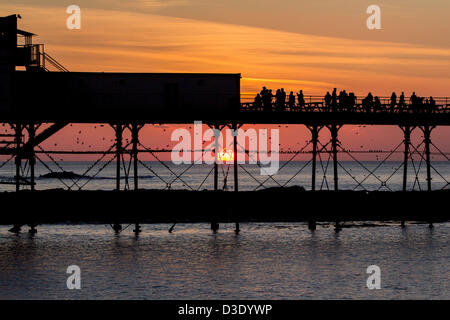 Sonnenuntergang in Aberystwyth und Tausende von Staren strömen, um in der Dämmerung unter Aberystwyth Pier Schlafplatz. Die spektakuläre Murmuration zieht Touristen aus nah und fern. Stockfoto