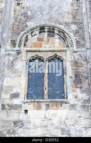 Glasmalerei-Fenster gesetzt in sehr alten Steinmauer bei Romsey Abbey UK Stockfoto