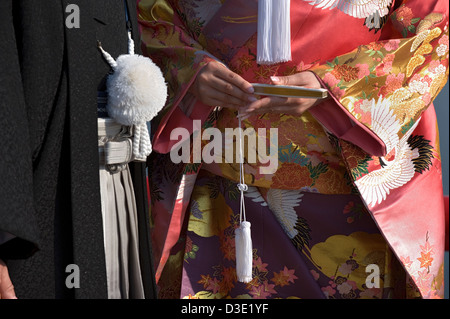 Eine Nahaufnahme Detail eine Braut hält ein gefaltetes Fan und Bräutigam tragen traditionelle Kimono bei ihrer Trauung in Japan. Stockfoto