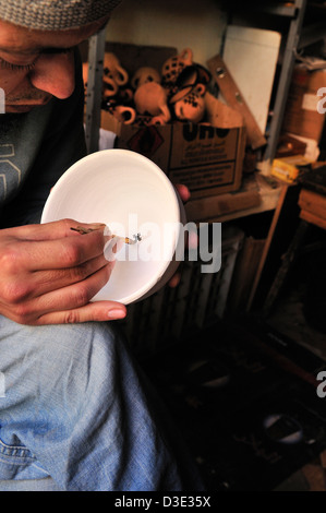 Berber Handwerker malen mit einem Stock und tupfte schwarzer Teer verzieren seine traditionelle aus Keramik in einem Markt-Souk von Marrakesch Stockfoto