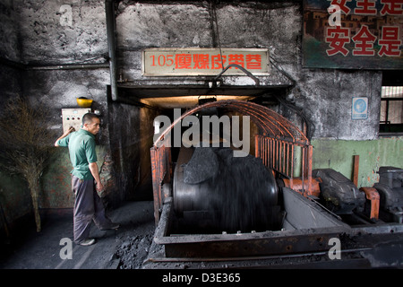 XIMING COAL MINE, TAIYUAN, CHINA - AUGUST 2007: Ein Förderband-Gürtel-Betreiber überwacht die Kohle auf dem Weg aus dem Bergwerk zu Lagerbestände unten. Stockfoto