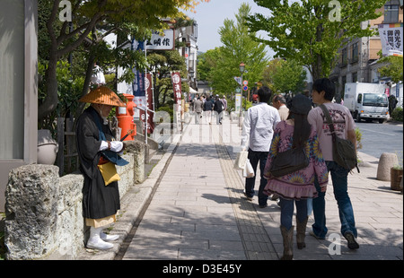 Touristen gehen buddhistischer Mönch betteln um Almosen auf Chuo-Dori (Main Street) in Nagano Stadt zwischen Bahnhof und Zenkoji Tempel Stockfoto