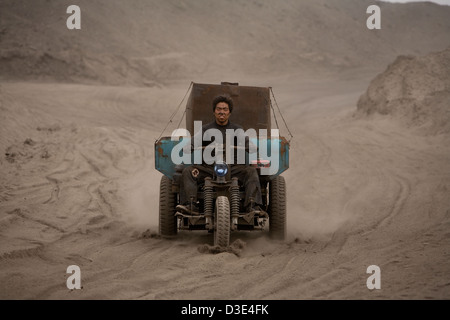 WUDA COAL FIELD, WU HAI, Innere Mongolei, CHINA - AUGUST 2007: Jin Cheng Gui, 20, treibt seine drei Rädern Pick-up entlang der staubige Feldwege Stockfoto