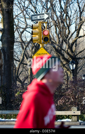 Von Fokus Läufer Joggen Vergangenheit abmelden "One Way" an der Spitze einer Verkehrsampel im New Yorker Central Park Stockfoto